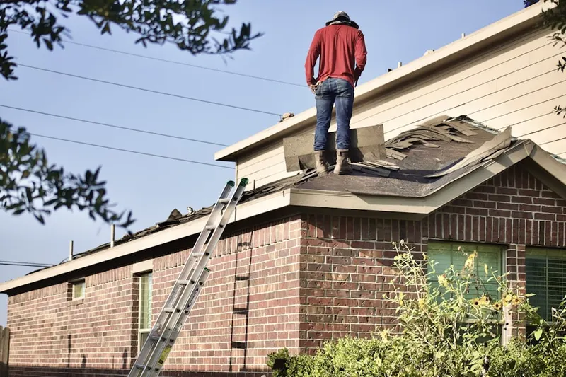 Professional roofer working on a residential roof in Fort Totten